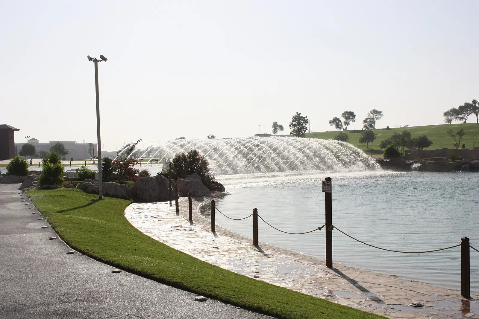 Lakeside walking path and fountain in Aspire Park, Doha