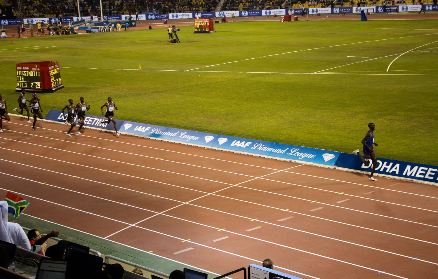 Runners on the track at Doha Diamond League meeting with stands behind