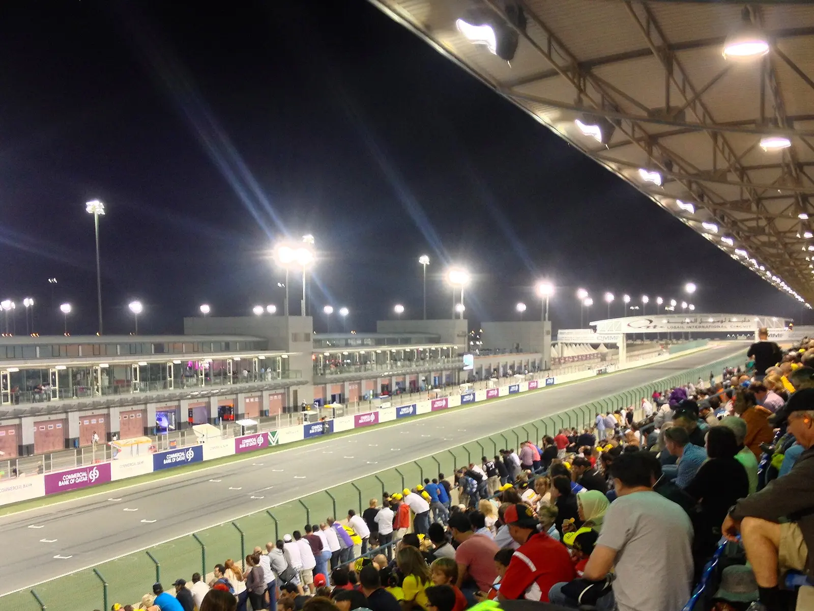 Floodlit main grandstand and pit straight of Losail International Circuit with spectators