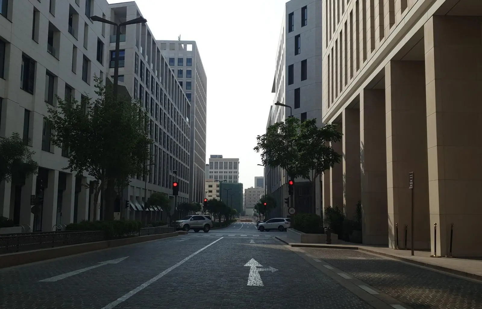 Sand-coloured buildings lining a quiet street in Msheireb Downtown Doha