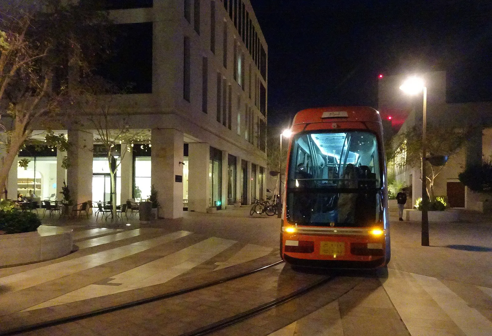A tram on a street in Msheireb Downtown Doha at night