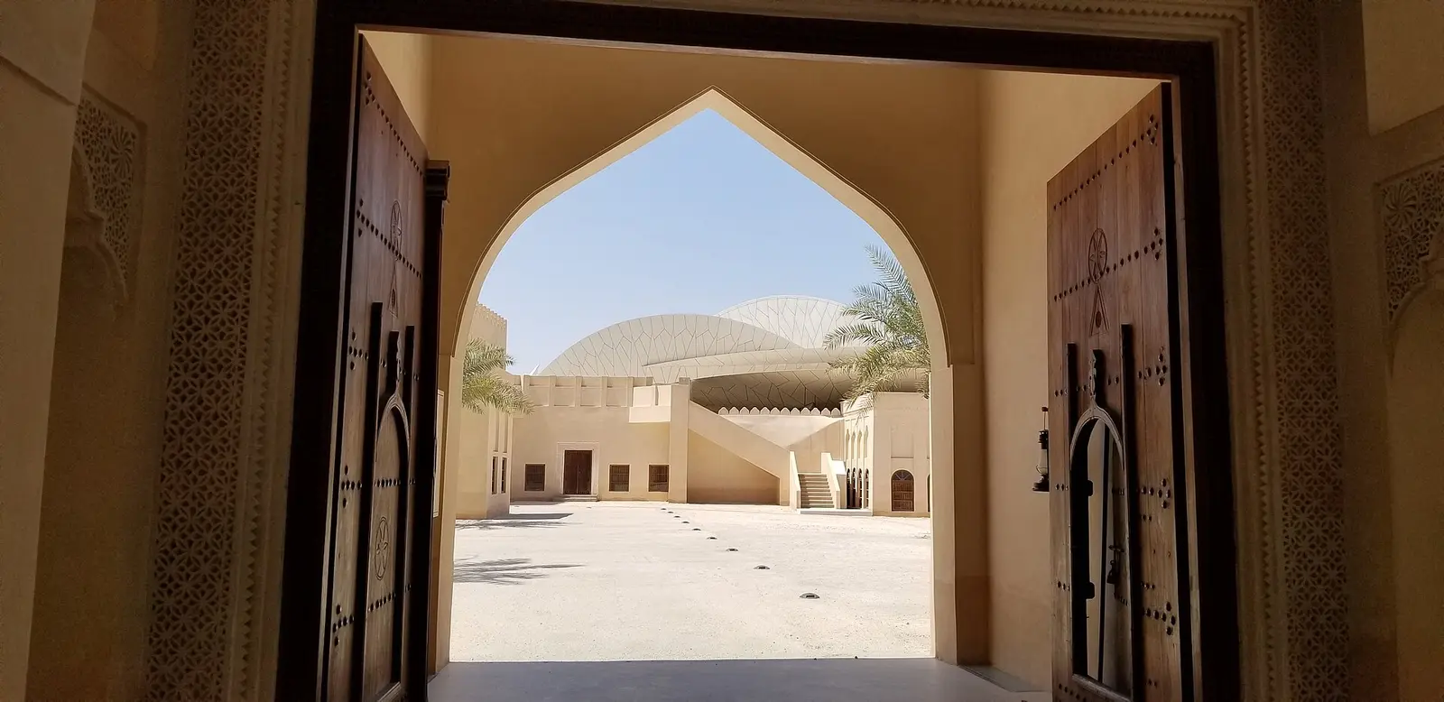 View of the National Museum of Qatar discs through an arched palace doorway